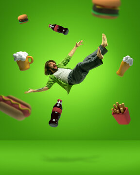 Forbidden food. Contemporary art collage with man levitating and screaming among junk food, beer, cola, french potato, sandwich, hot dog on green background. Concept of dietary, bad habits, adiposity
