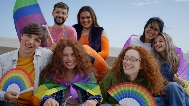 Different excited young friends group celebrating gay pride festival day together. Joyful people LGBT community pose funny looking at camera outdoors. Lesbian, gay, transgender