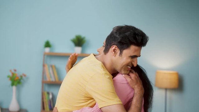 Happy indian Adult son hugging his senior mother by kissing on forehead at home - concept of grateful, emotional bonding and motherhood