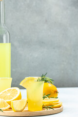 italian lemon alcohol drink limoncello with lemon and rosemary. vertical image. top view. place for...