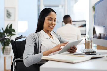 Comparing notes. an attractive young businesswoman working on a tablet at her desk in the office.