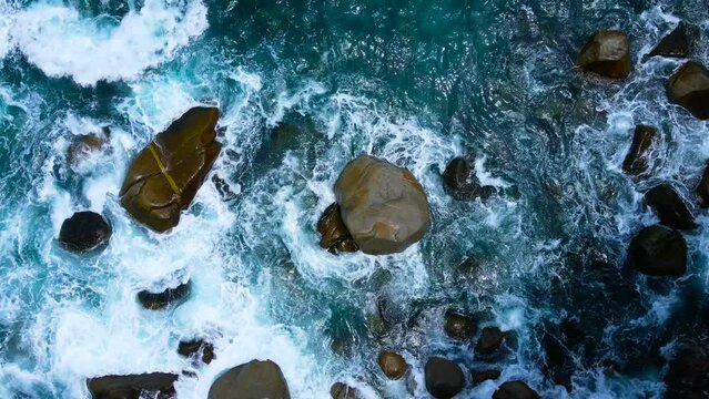 Top-view blue water wave sea. 4K Cinematic scene Aerial View top-view water wave texture in nature Beautiful wave on rock beach top-down view High quality video ProRes 422