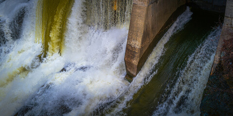 Sherbrooke Dam with overflowing water after spring rain storm at Magog River, downtown Sherbrooke,...