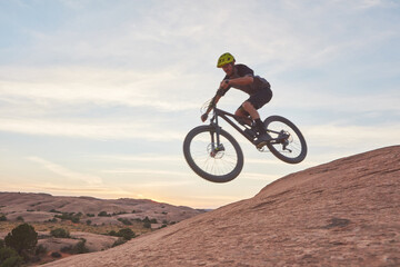 Do one thing that scares you every day. a young man out mountain biking during the day.