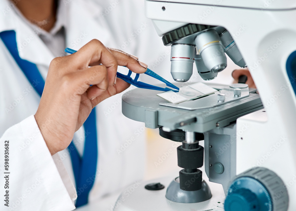 Poster The answer is about to lie crystal clear. an unrecognizable female scientist placing a microscopic slide under the microscope while working in a laboratory.