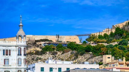 Architectural contrast in Alicante, Spain. Buildings and part of the medieval castle. 