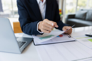 Male businessman working with calculator, business document and laptop computer notebook at room office.
