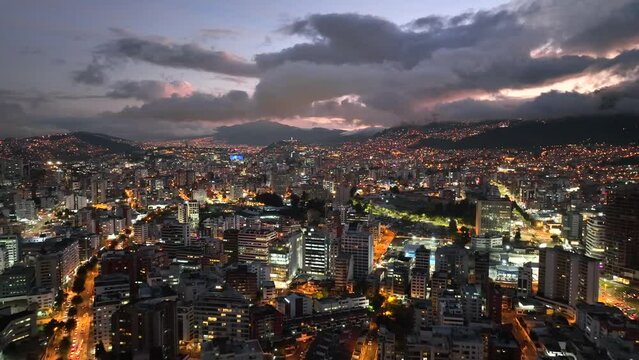 Aerial drone footage of Quito, Ecuador at night with the city lights on just after sunset