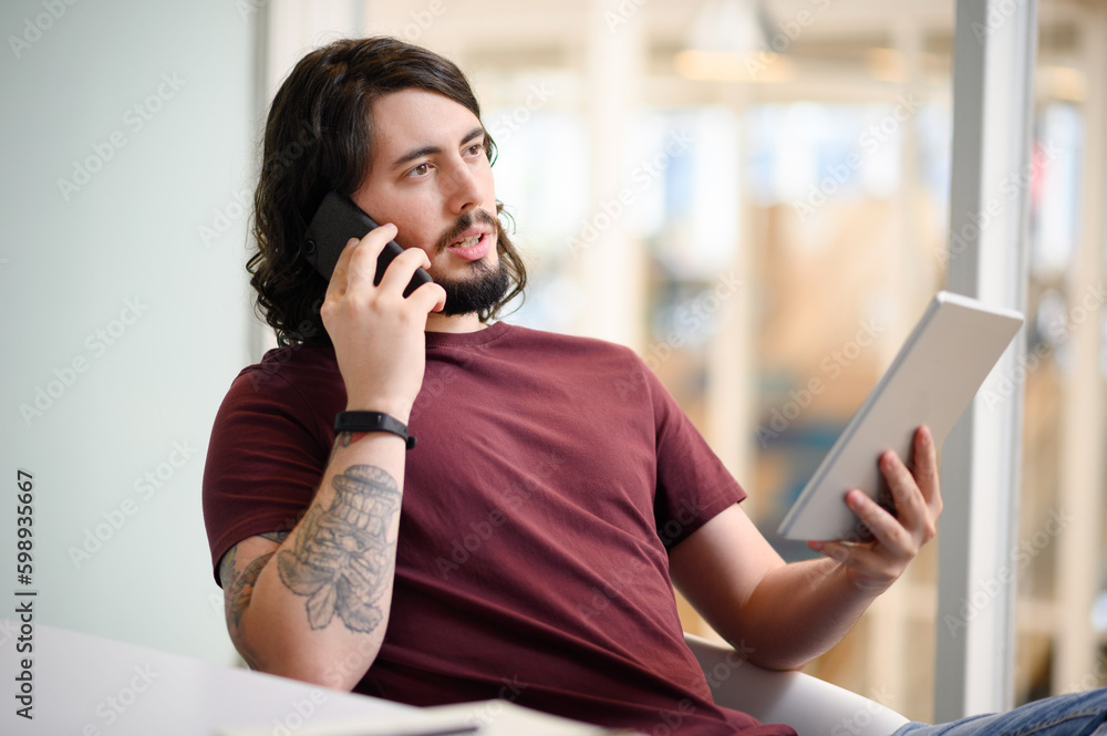 Poster innovation is what adds value to his business. a young businessman talking on a cellphone while usin