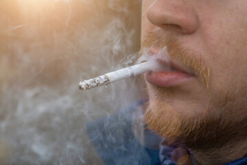 Close up portrait of young man smoking cigarette - obrazy, fototapety, plakaty