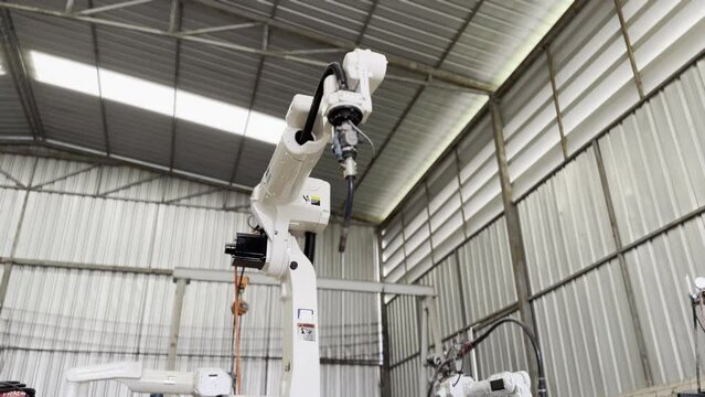 Robotic Arm engineer check on equipment in its with software of an Artificial Intelligence Computer Processor Unit.. Industrial factory employee working in metal manufacturing industry