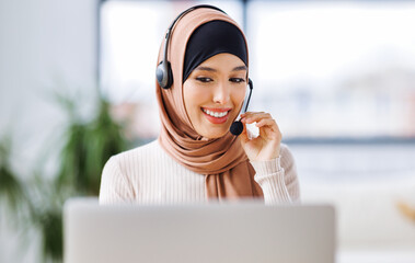 friendly smiling muslim woman  with headset working in front of laptop talking while calling client