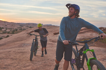 The pursuit of mountain biking has taken us many places. Full length shot of two men out mountain...