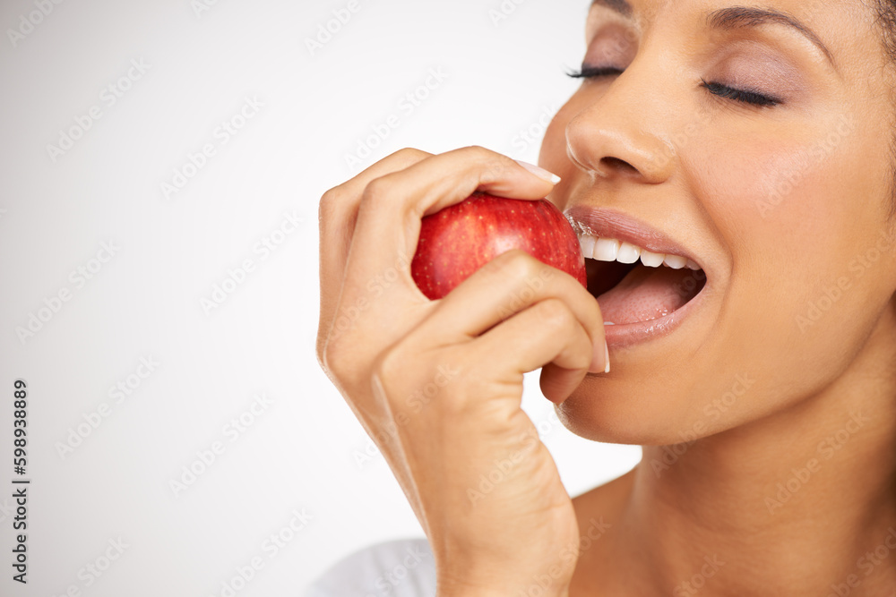 Wall mural An appetite for juicy apples. Portrait of a young woman enjoying a healthy snack.