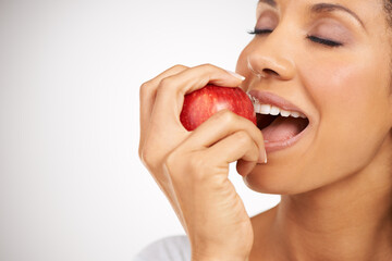 An appetite for juicy apples. Portrait of a young woman enjoying a healthy snack.