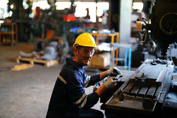 Lathe Operators Concentrated on Work. Worker in uniform and helmet works on lathe, factory. Industrial production, metalwork engineering, manufacturing.