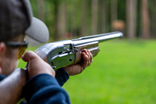 Skeet Shooting .Man shooting at target on an outdoor shooting range at sunny day, training alone, confident and skilled, experienced. Shooting and Guns.