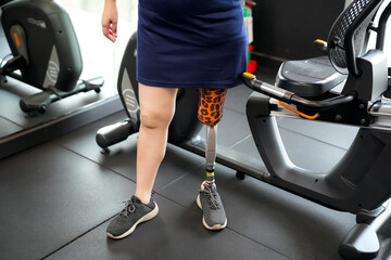 Portrait of disabled athlete woman with prosthetic leg in fitness gym