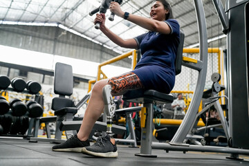 Disabled athlete with leg prosthesis training at the gym. Paralympic Sport Concept.