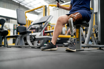 Fototapeta na wymiar Disabled athlete with leg prosthesis training at the gym. Paralympic Sport Concept.