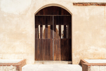 Pórtico de madera de acceso a claustro de edificio religioso.