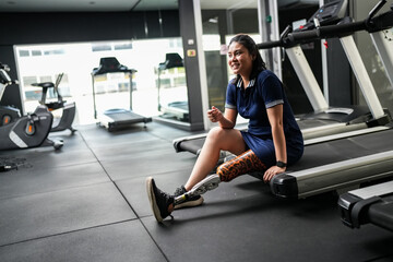 Disabled athlete with leg prosthesis training at the gym. Paralympic Sport Concept.