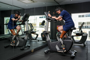 Disabled athlete with leg prosthesis training at the gym. Paralympic Sport Concept.