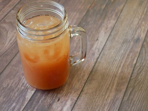 jar of grapefruit juice in a kilner glass on a wooden table