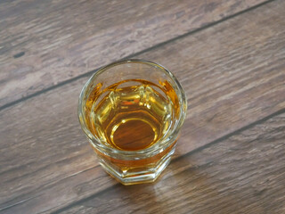 single shot glass of brandy close up on wooden table bar setting