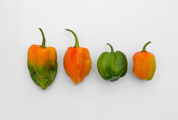 Different fresh raw hot chili peppers on white background, flat lay