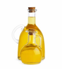 Glass jugs of cooking oil on white background