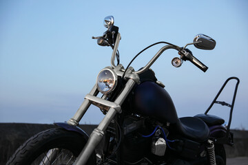 Modern black motorcycle against blue sky outdoors