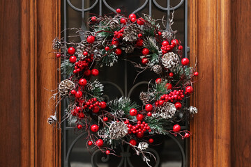 Beautiful Christmas wreath hanging on wooden door © New Africa