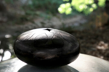 Steel tongue drum on stone outdoors. Percussion musical instrument