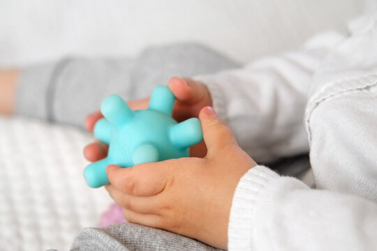Cute baby girl playing tactile knobby balls. Young child hand plays sensory massage ball. Enhance the cognitive, physical process. Brain development. Support for Children with ADHD, autism, fidgeting