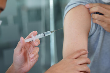 General practitioner or doctor vaccinating old patient in clinic..