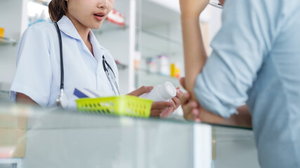 Obraz premium Asian woman pharmacist Helping Customer with Medicine at Pharmacy Drugstore