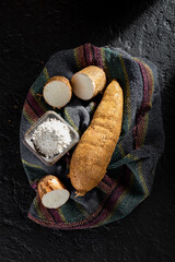 pile of cassava and cassava flour on dark background (Manihot esculenta)