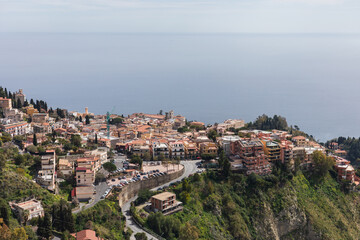 Fototapeta na wymiar Panormaic view on Taormina town on top of a hill in Sicily on beautiful day