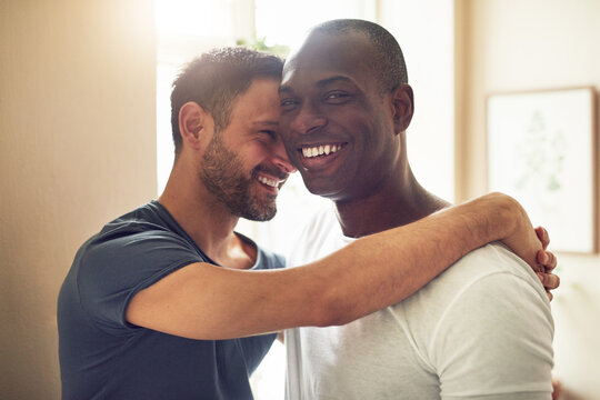 Cheerful alternative gay couple smiling and embracing together