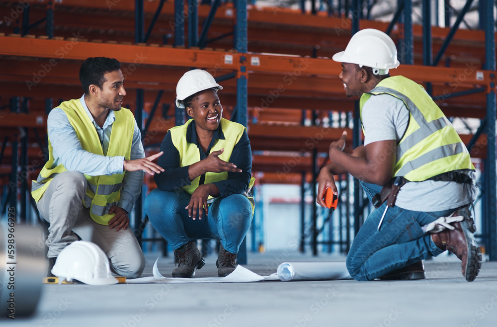 Poster What would you suggest. a group of contractors crouching down in the warehouse together and using a blueprint to plan.