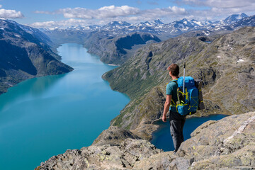 Wanderer auf dem Besseggen Grat mit Blick auf Gjende See, Jotunheimen Nationalpark, Norwegen - obrazy, fototapety, plakaty
