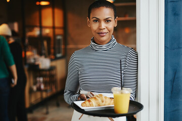 Friendly waitress standing with food in a cafe