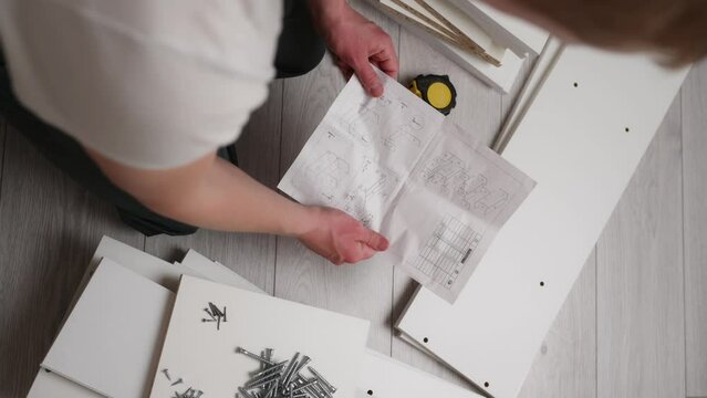 The furniture assembler is studying the instructions for assembling furniture.The concept of moving, repair Generative AI