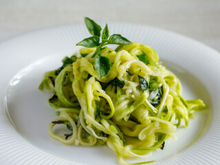 Salad of marinated raw zucchini spaghetti in spices and herbs. Vegan food. Healthy meal. Side view, close up