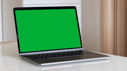 A Green Screen Laptop on a White Table at Home