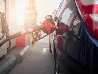  A fuel pump plugs into a car. Filling gasoline into a car at a gas station.