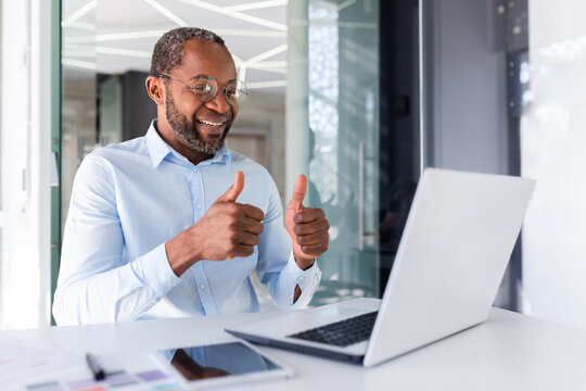 Video call on online meeting, african american businessman boss talking to colleagues partners showing laptop camera thumbs up satisfied with team work achievement results.