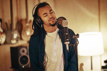 Young musical artist singing in a recording studio