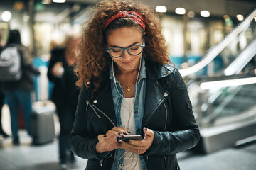 Young woman reading a text while waiting for her train